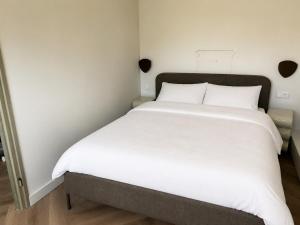 a large white bed in a small room at De Kustwacht in Warmenhuizen