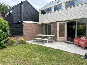 a patio with a picnic table next to a house at De Kustwacht in Warmenhuizen