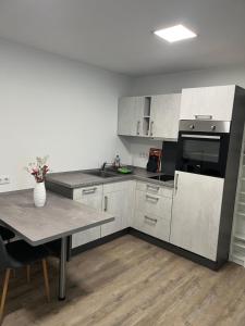 a kitchen with white cabinets and a table with flowers at Ferienwohnung Krayenbergblick 1 in Bad Salzungen