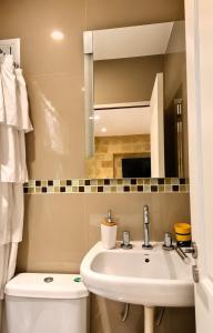 a bathroom with a sink and a toilet and a mirror at Los Medanos 1 in Puerto Madryn