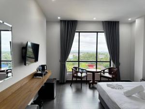 a hotel room with a bed and a table with chairs at De Zee Hotel in Koh Kong