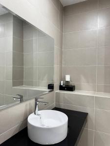 a white bathroom with a sink and a mirror at De Zee Hotel in Koh Kong