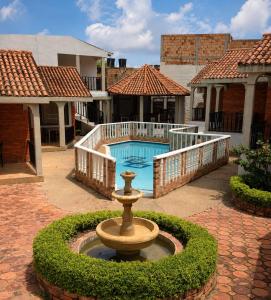 a fountain in a courtyard next to a swimming pool at Hotel Aguablanca in La Mesa