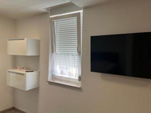 a room with a flat screen tv and a window at Ferienwohnung Krayenbergblick 1 in Bad Salzungen