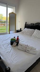 a white bed with towels and a mirror on it at Appartement avec piscine, résidence assadaka in Saïdia +19 photos