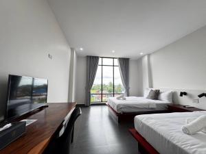 a hotel room with two beds and a flat screen tv at De Zee Hotel in Koh Kong +25 photos
