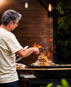 a man cooking food on top of a grill at Pensiunea Mirage in Iaşi