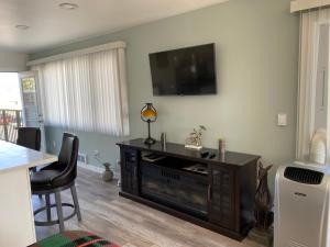 a living room with a flat screen tv on the wall at Soundview Ferry Cottage in Mukilteo
