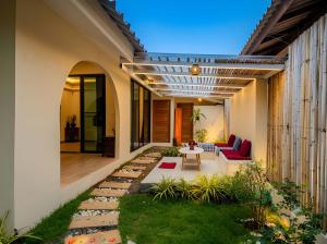 a patio of a home with a table and chairs at The Arya Srithanu in Ko Kong Nui
