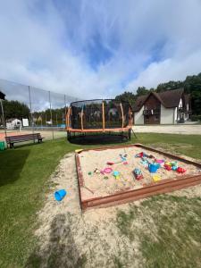 a playground with a sand pit in a park at Apartament Łeba in Żarnowska