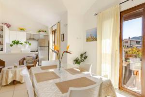 a white dining room with a table and a window at Il Girasole - Appartaments in Domus de Maria