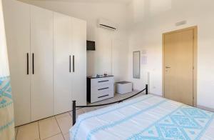 a bedroom with a bed and white cabinets and a dresser at Il Girasole - Appartaments in Domus de Maria