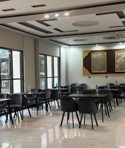 a dining room with tables and chairs and windows at Comfort Inn in Kalām