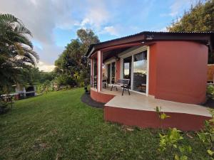 a small red house with a large yard at La Rond'Dada in Sainte-Suzanne