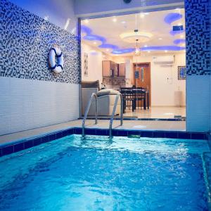 a swimming pool in a room with a kitchen at شاليهات رميس in Abha