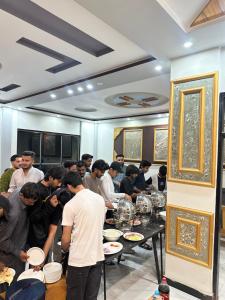 a group of people standing around a table eating food at Comfort Inn in Kalām +39 photos