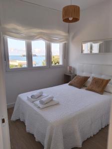 a white bedroom with a bed with towels on it at Casa Roca Blanca Suances in Suances
