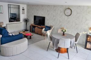 a living room with a table and chairs and a clock at Celies Country Cottage in Blaru