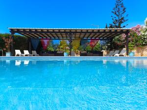 a swimming pool with a pergola and chairs at Aurora Sol in Luz