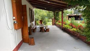 a porch of a building with benches and flowers at Dobó Tanya in Röszke