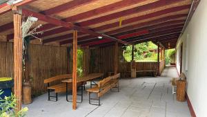 a wooden pergola with a table and benches on a patio at Dobó Tanya in Röszke