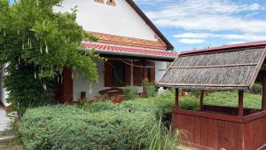 an old house with a thatched roof and a garden at Dobó Tanya in Röszke