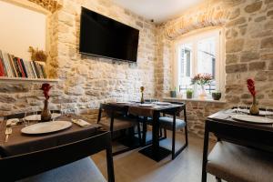 a restaurant with two tables and a tv on the wall at Murum Heritage Hotel in Split