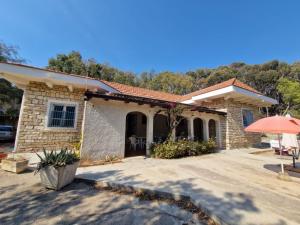 a stone house with a patio and an umbrella at Villino Irmgard in Butera