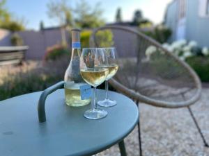 a bottle of wine and two glasses on a table at B&B Tierlantijn in Hamont