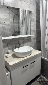 a bathroom with a white sink and a mirror at Квартира в центре города in Komrat