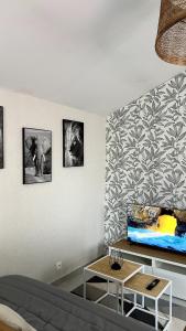 a living room with a couch and a table at Maison 2 couchages - parking in La Chaussée-sur-Marne