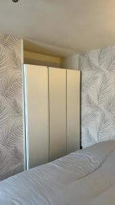 a bedroom with a bed with white sheets at Maison 2 couchages - parking in La Chaussée-sur-Marne