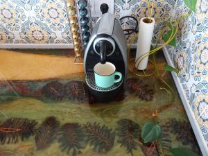 a coffee maker with a cup sitting on a table at Carma de Madeira Lodge in Penela