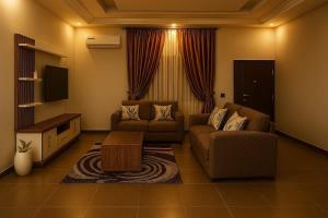 ein Wohnzimmer mit Sofa und Fernseher in der Unterkunft Zenith House in Ibadan