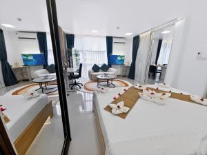 a bedroom with two beds and a living room at Dee Residence Phuket in Patong Beach
