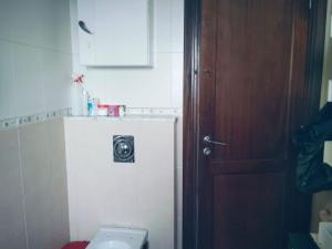 a bathroom with a toilet and a door with a camera at belle appart de luxe CUN in Tunis