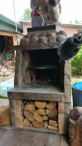 an outdoor stone fireplace with a pile of logs at Domek Augustów Monika in Augustów