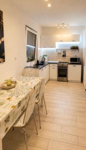 a kitchen with a table and chairs and a kitchen with white cabinets at Ametystowa Street in Września