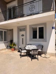 a patio with a table and chairs under a balcony at IK Apartments in Rake