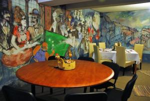 a dining room with a table and a mural at Pension La Noblesse in Bucharest