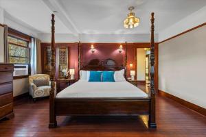 a bedroom with a canopy bed and a chair at Stonehurst Estate Sleep 16 in Chilliwack