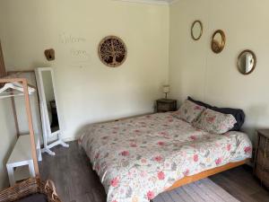a bedroom with a bed and a mirror on the wall at B&B Bombon in Herk-de-Stad