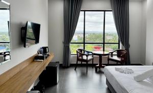 a hotel room with a table and chairs and windows at De Zee Hotel in Koh Kong