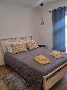a bedroom with a bed with two towels on it at Casa Serra e Mar in Luz +23 photos
