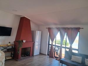 a living room with a fireplace and a large window at Casa Serra e Mar in Luz
