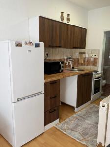 a kitchen with a white refrigerator and wooden cabinets at gvero apartments in Prilep