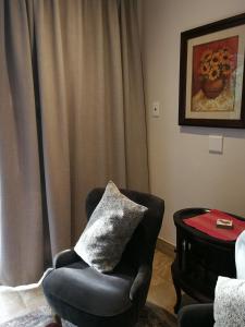 a living room with a chair and a table at Martin Villa in Somerset West
