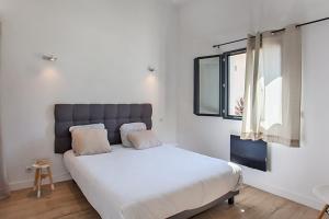 a bedroom with a large white bed and a window at Casa Sol location de vacances indépendante à Calvi moins de 2km plage in Calvi