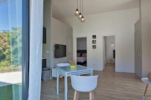 a living room with a table and chairs and a television at Casa Sol location de vacances indépendante à Calvi moins de 2km plage in Calvi