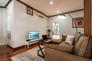 a living room with a couch and a television at BlueHome Apartment in Vientiane